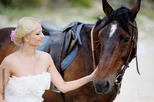 Beach wedding: bride and a horse by the sea