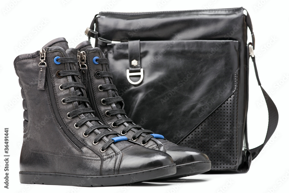Naklejka premium Pair of black ankle-high men boots and shoulder bag
