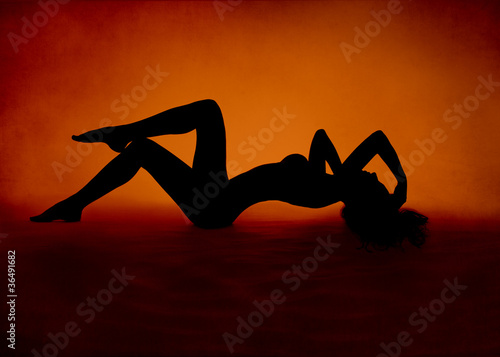 woman sexy silhouette lying at red orange background