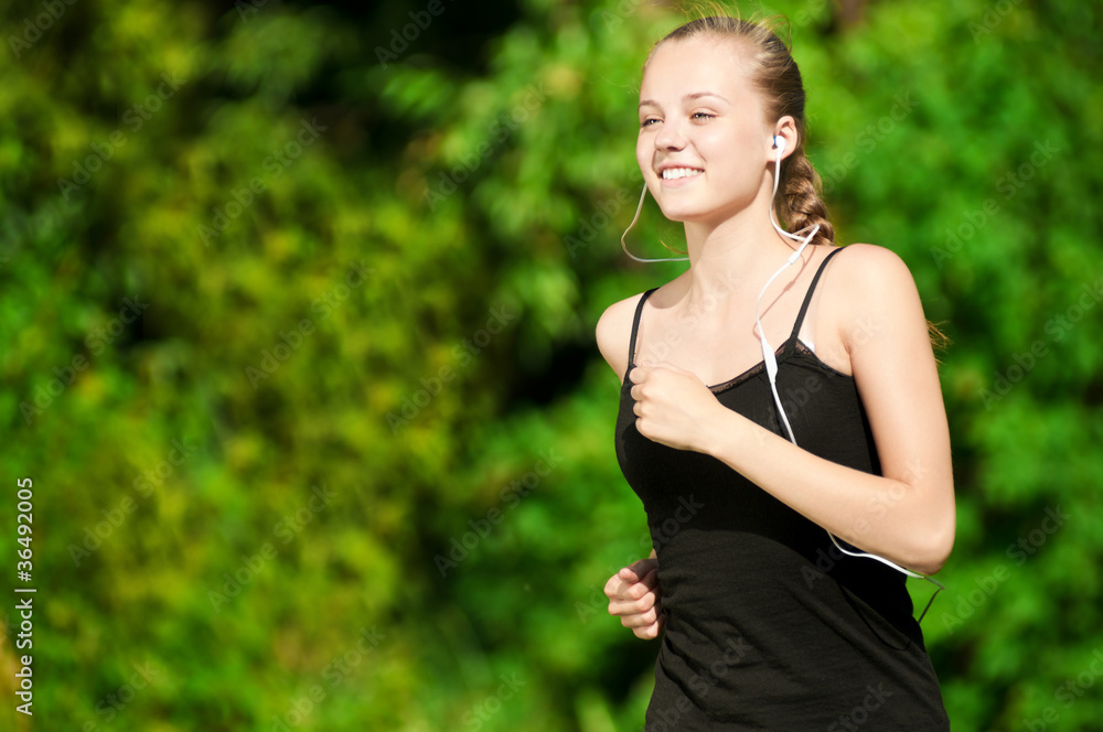 Young woman running in green park Young woman running in green park
