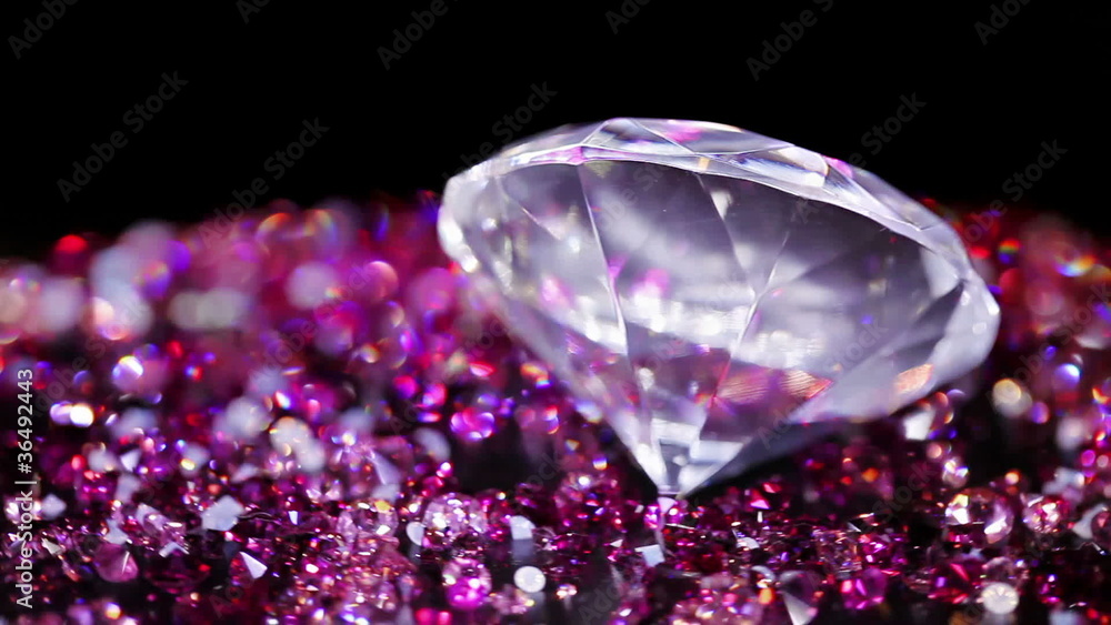 Big jewel stone with many violet small one rotating over dark Big jewel stone with many violet small one rotating over dark