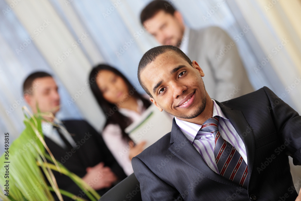 Happy african-american businessman with his team working behind Happy african-american businessman with his team working behind