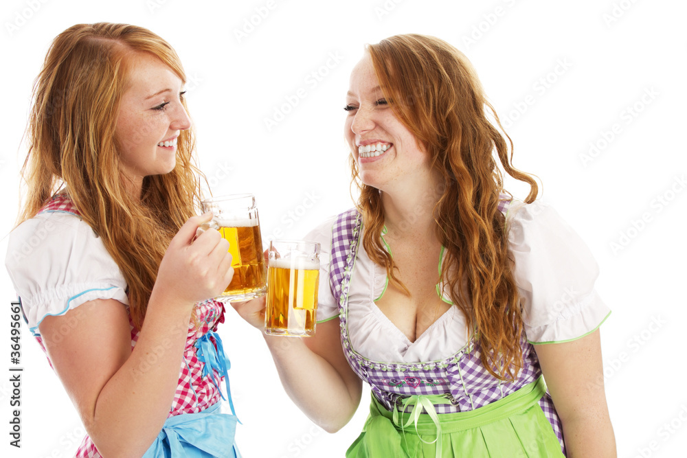 zwei glückliche frauen in dirndl beim anstossen mit bier zwei glückliche frauen in dirndl beim anstossen mit bier