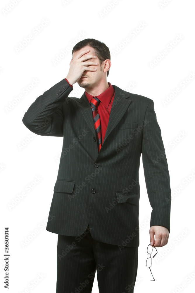 Businessman covers his eyes with one hand Businessman covers his eyes with one hand
