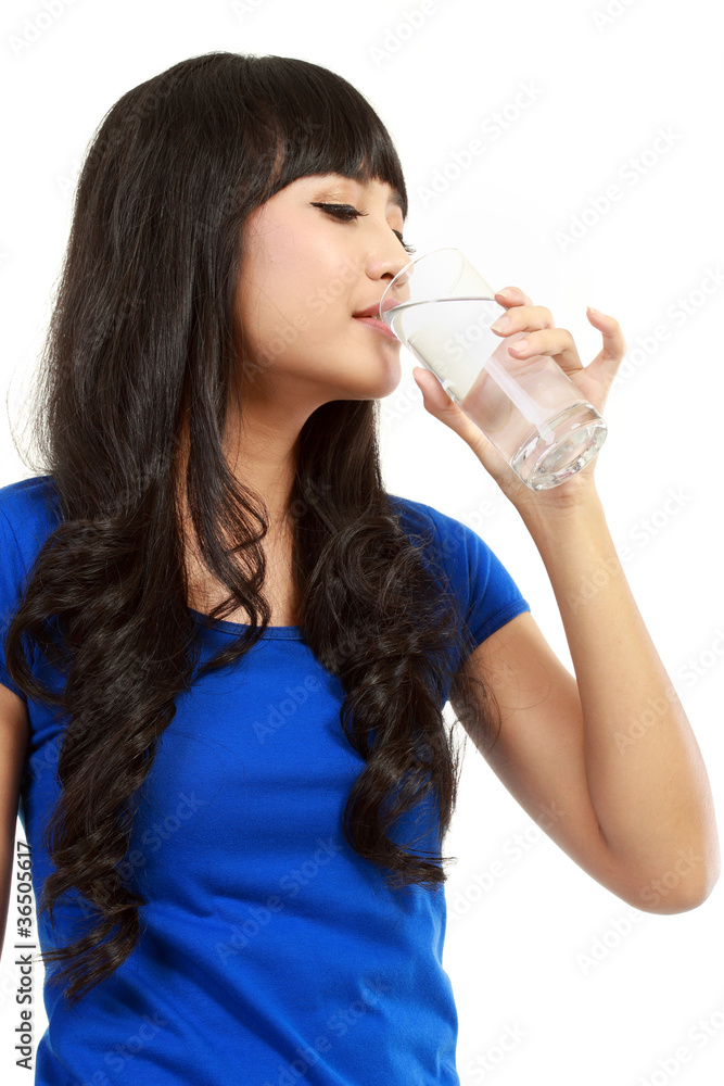 Beautiful young girl drinks water from glass Beautiful young girl drinks water from glass