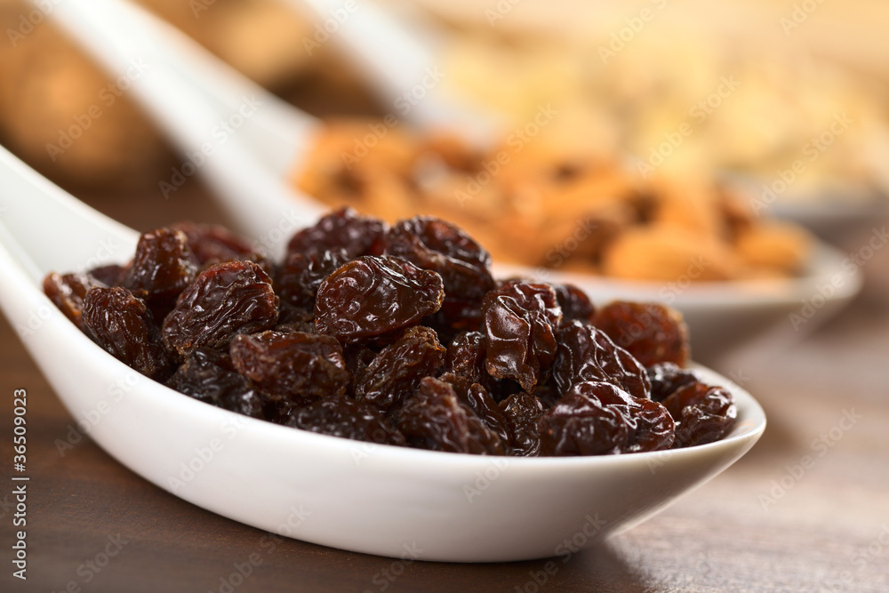 Raisins on ceramic spoon Raisins on ceramic spoon