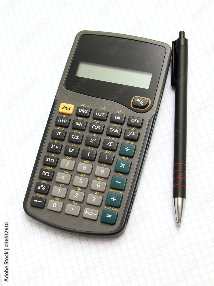 Scientific calculator and pan on notebook paper Scientific calculator and pan on notebook paper