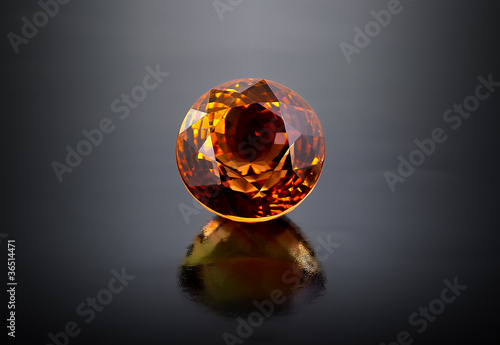 Single round citrine gemstone on dark background.