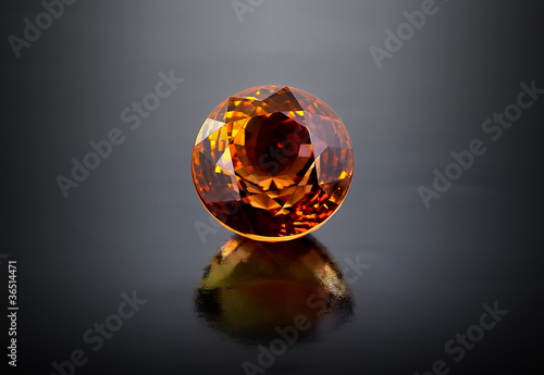 Single round citrine gemstone on dark background. photo