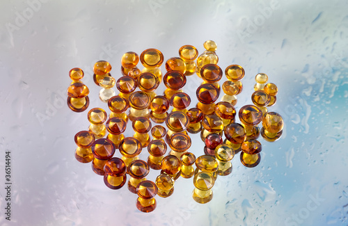 Group of citrine gemstones on wet mirror.