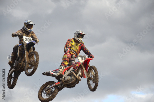 Fototapeta Naklejka Na Ścianę i Meble -  Flying high two motocross racing against