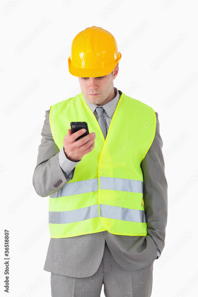 Portrait of a young builder looking at his cellphone Portrait of a young builder looking at his cellphone
