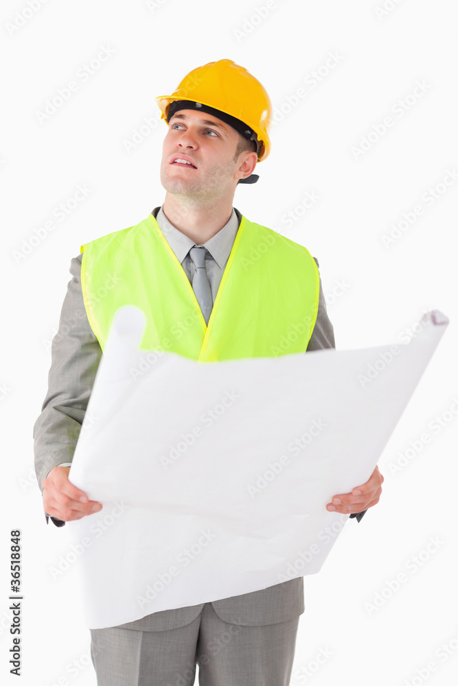 Portrait of a builder looking around while holding a plan Portrait of a builder looking around while holding a plan