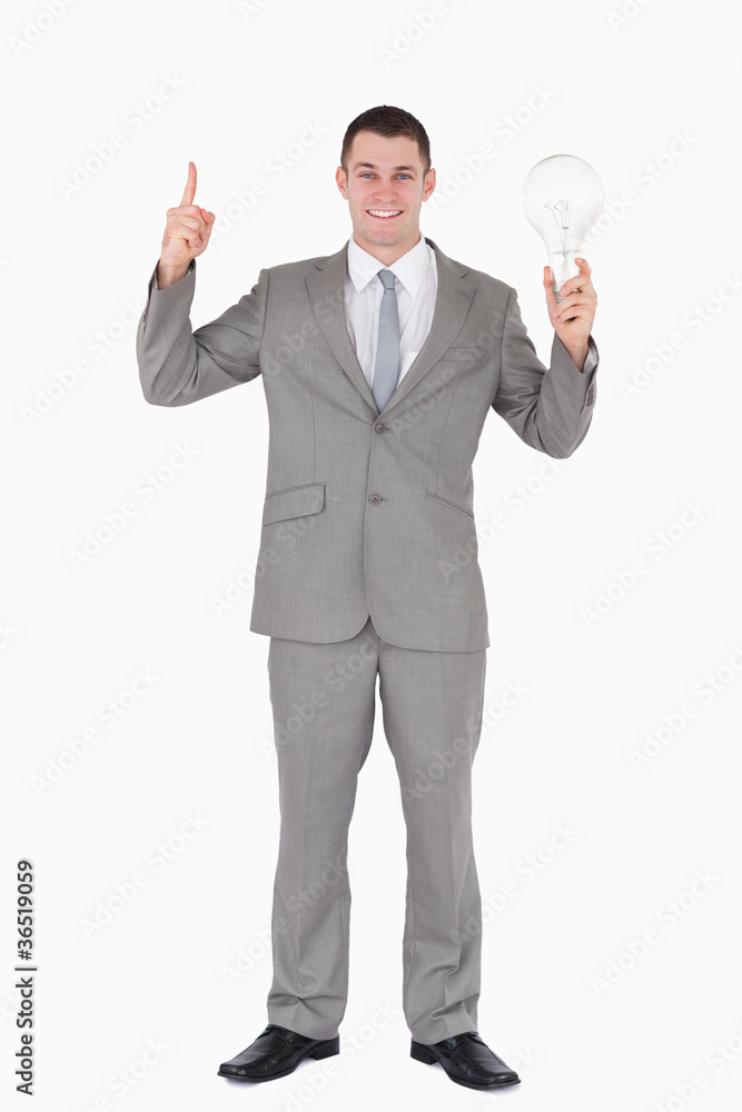 Portrait of a businessman holding a bulb and pointing at somethi Portrait of a businessman holding a bulb and pointing at somethi