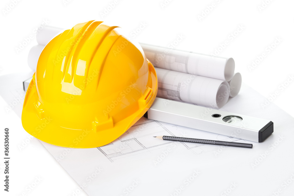 Naklejka premium Yellow helmet on house project construction plan