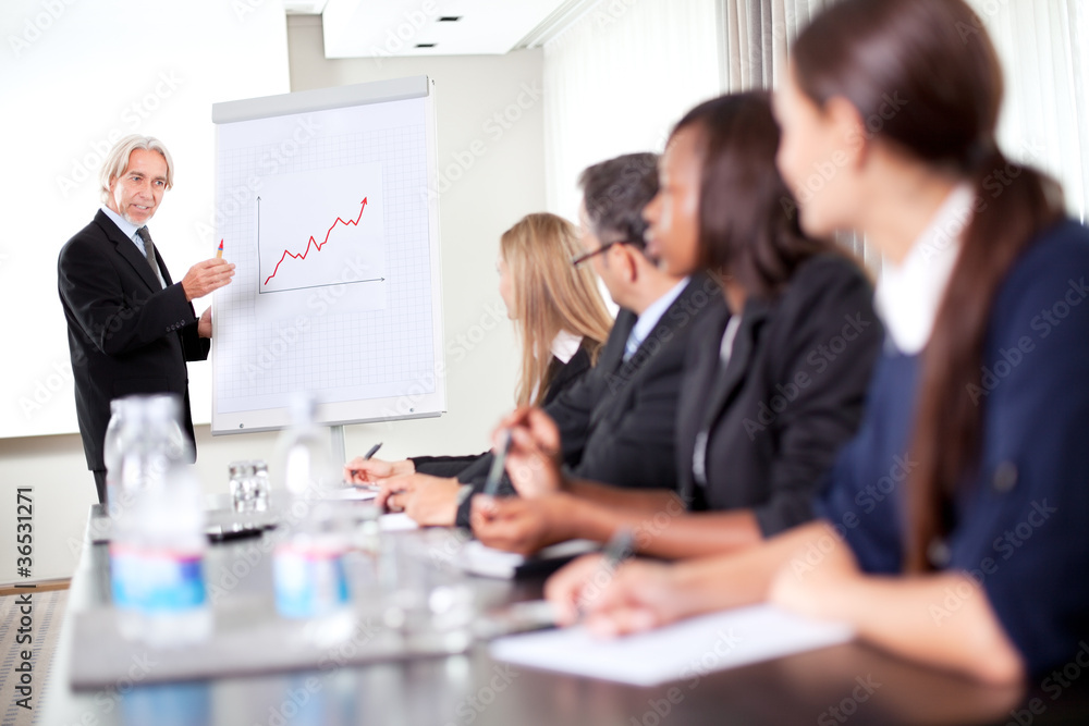 Business man explaining to his team sales team Business man explaining to his team sales team