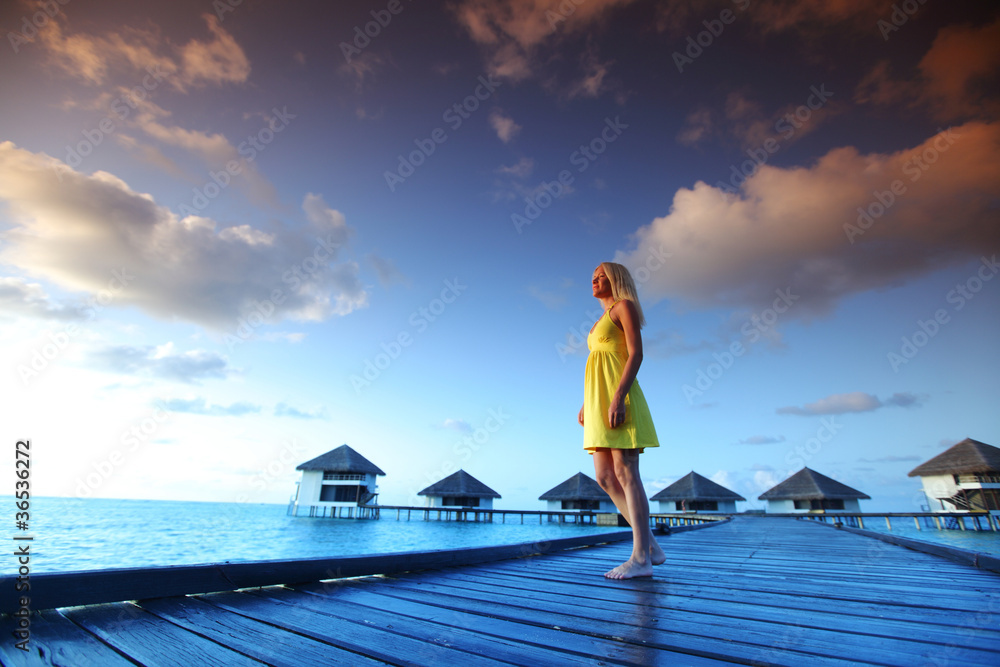Fototapeta premium woman in a dress on maldivian sunset
