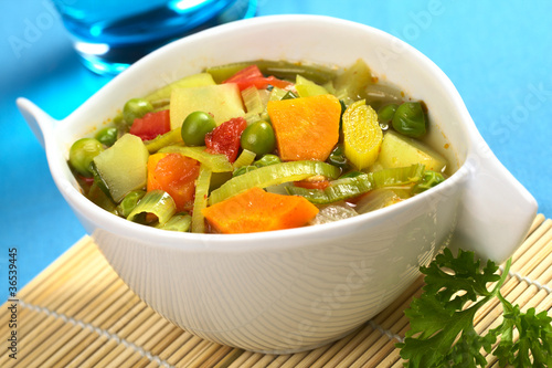 Vegetable soup made of carrot, leek, pea, potato, onion, tomato