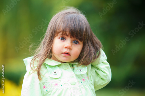 little girl in green walking park.