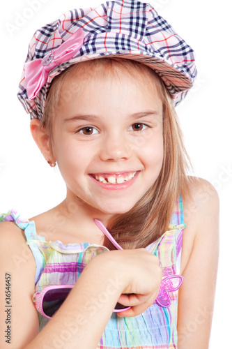 Beautiful little  girl in a cap over white