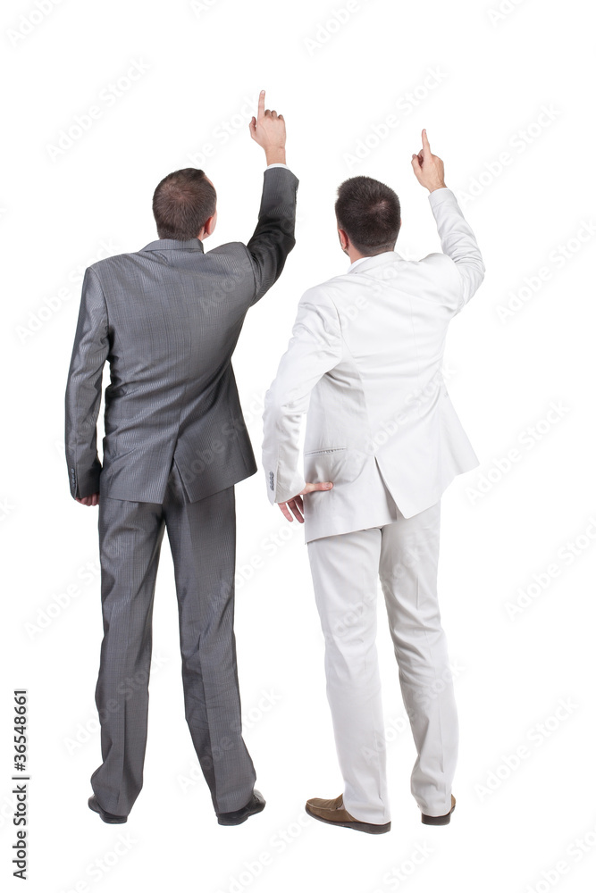 Back view of two businessman pointing at wall. rear view. Isolat