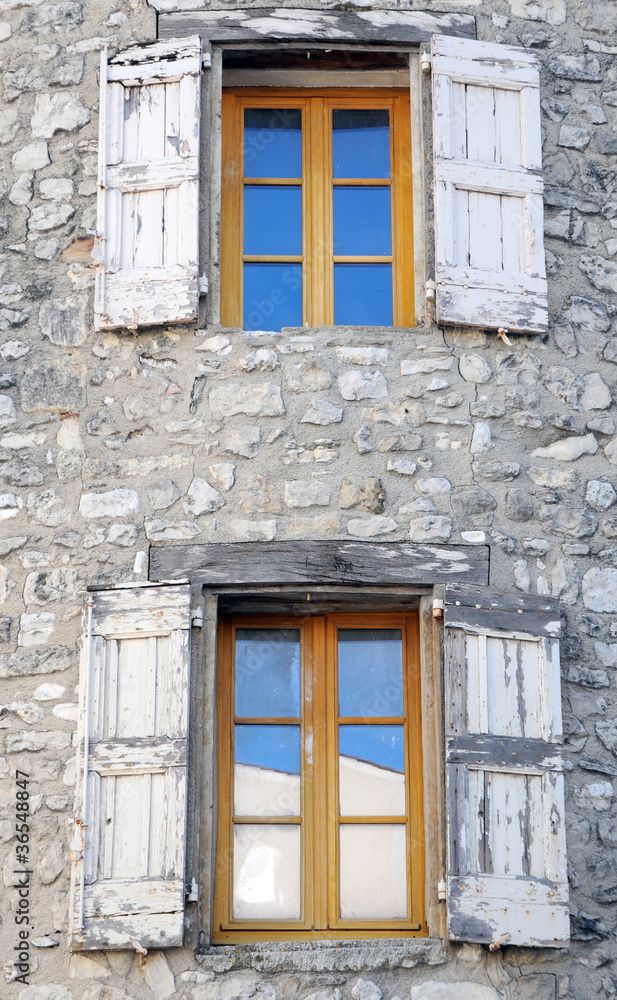 Windows on old stone house in Sault, Provence in France Windows on old stone house in Sault, Provence in France