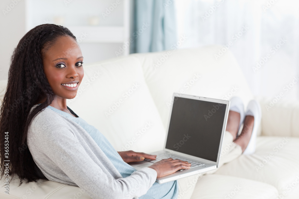 Smiling woman with notebook on sofa Smiling woman with notebook on sofa