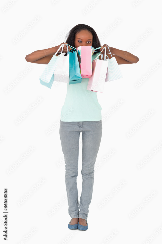 Woman hiding behind her shopping on white background Woman hiding behind her shopping on white background