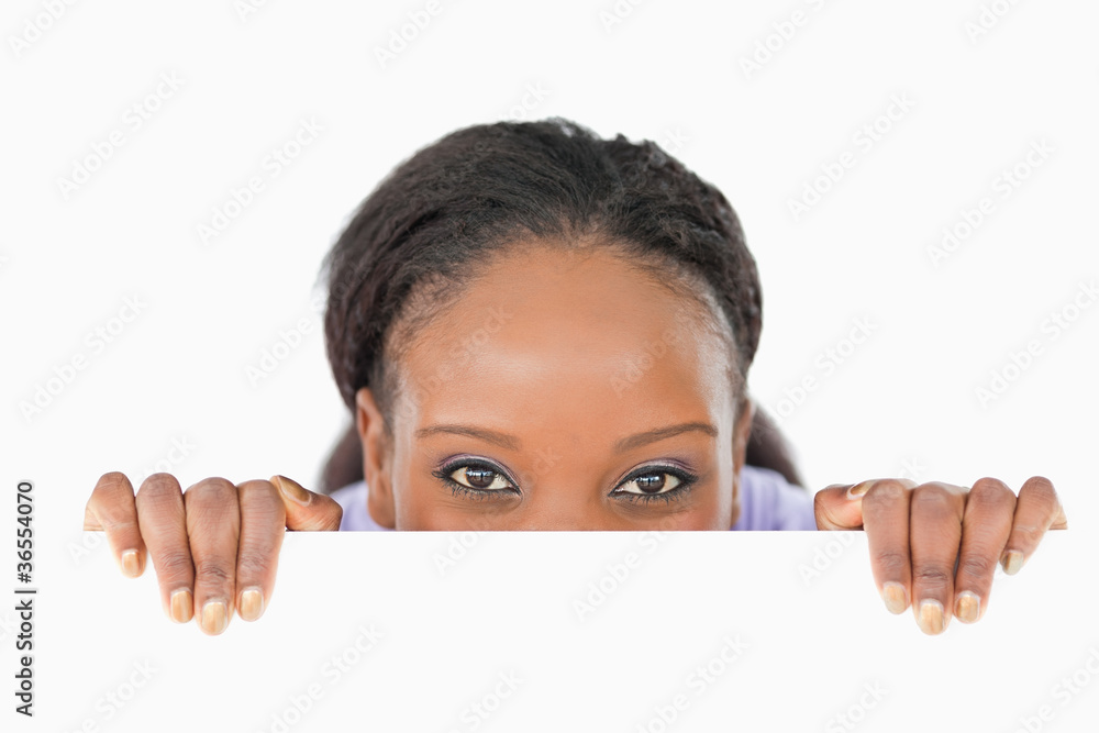 Woman taking a look above an edge on white background Woman taking a look above an edge on white background