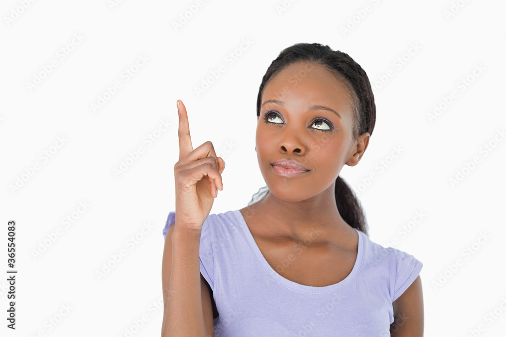 Close up of woman pointing upwards on white background Close up of woman pointing upwards on white background