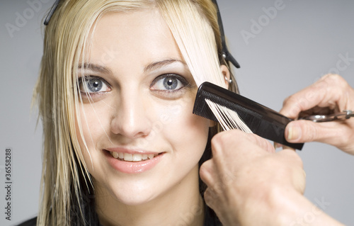 Hairdresser cutting hair with comb