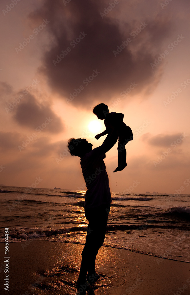 the silhouette of happy father and little girl on the beach