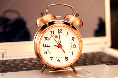 Old alarm clock on laptop keyboard