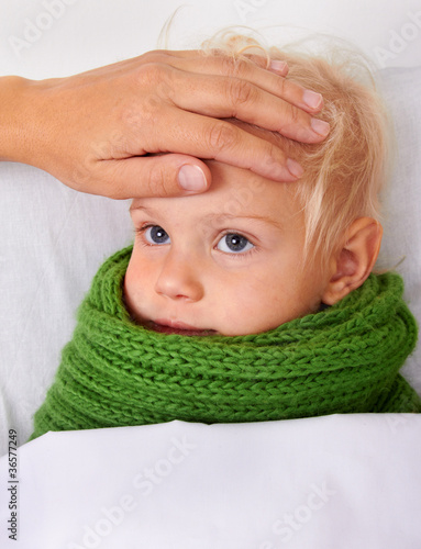 Woman checks the temperature of a sick baby
