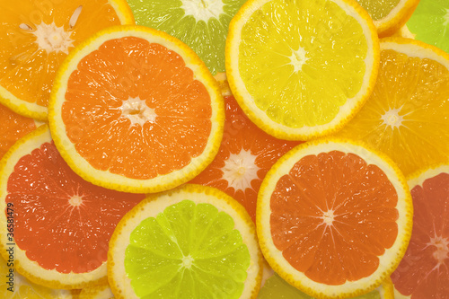 Sliced citrus fruits in different colors, background