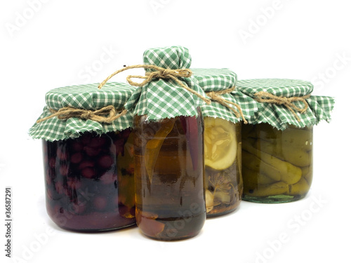 bottle of chilli oil, jar with preserved cherries, pickled cucum photo