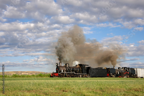 Vintage steam locomotive with billowing smoke and steam