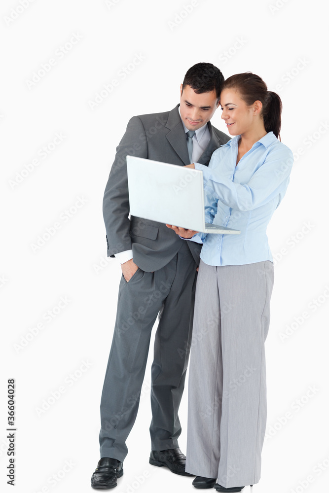 Business partner looking at a laptop against a white background Business partner looking at a laptop against a white background