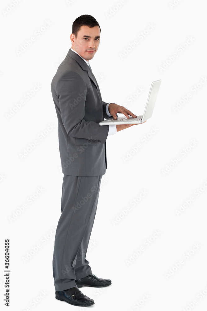 Confident businessman with laptop against a white background Confident businessman with laptop against a white background