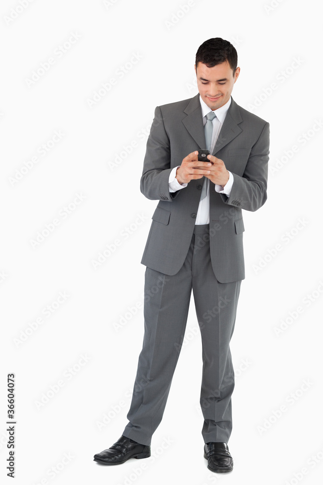 Businessman reading textmessage against a white background