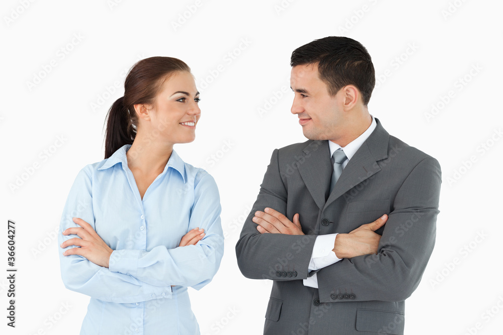 Business partners with arms folded looking at each other Business partners with arms folded looking at each other