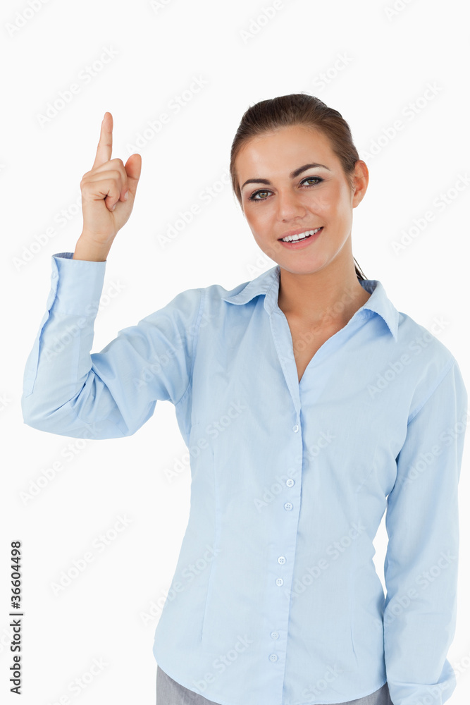 Smiling businesswoman pointing upwards