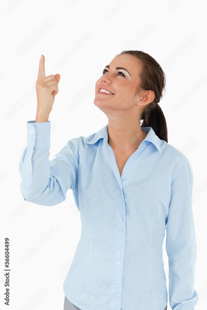 Smiling businesswoman looking and pointing upwards Smiling businesswoman looking and pointing upwards