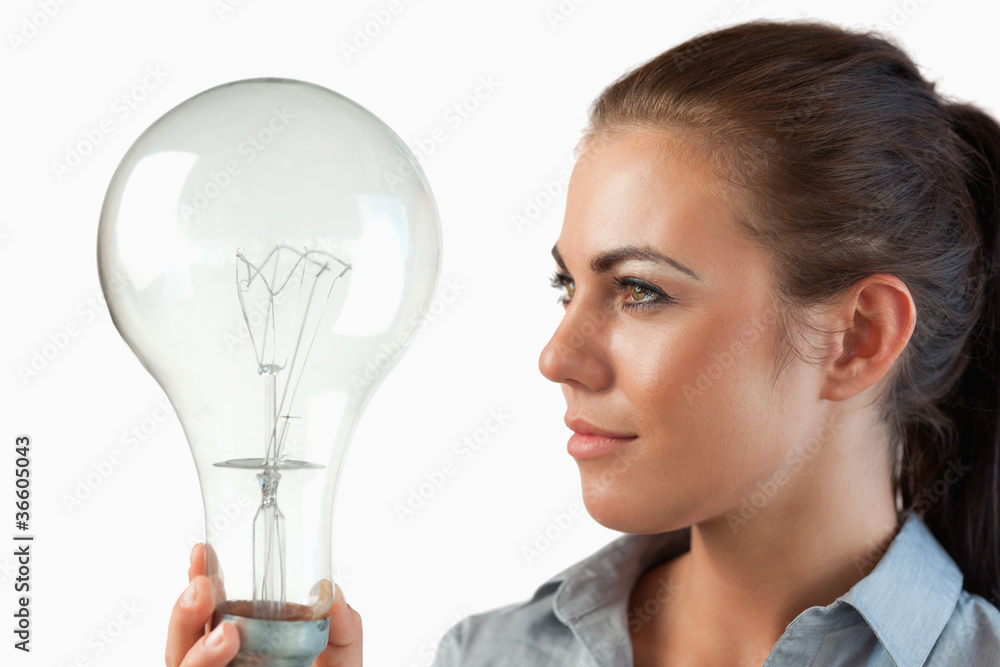 Businesswoman looking at huge light bulb in her hand Businesswoman looking at huge light bulb in her hand