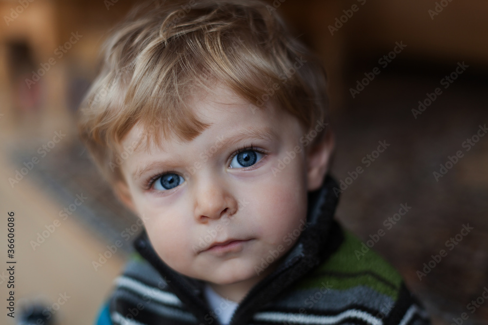 adorable baby boy with blond hairs and blue eyes