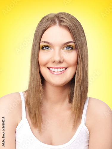 portraits of young happy blond girl on yellow background