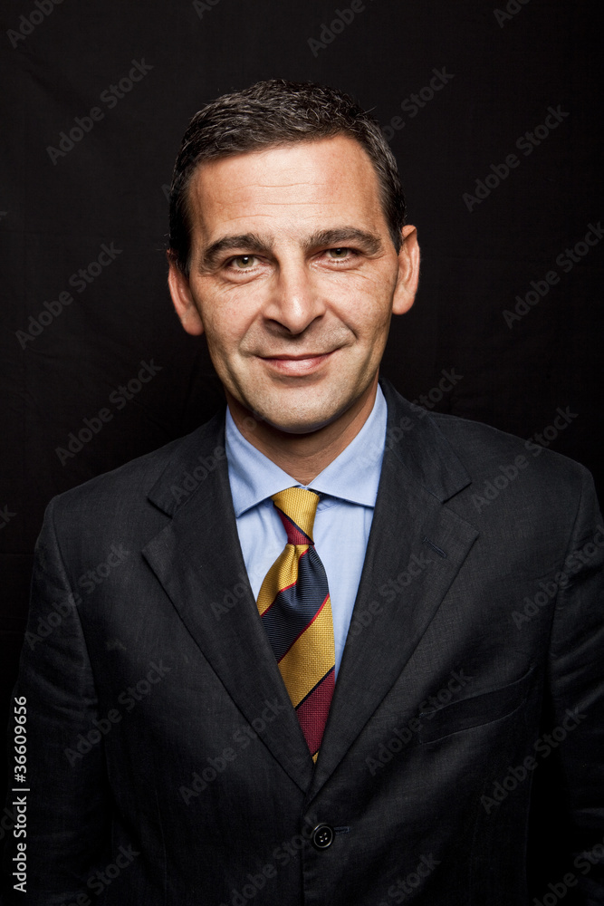 Portrait of confident businessman over black background Portrait of confident businessman over black background
