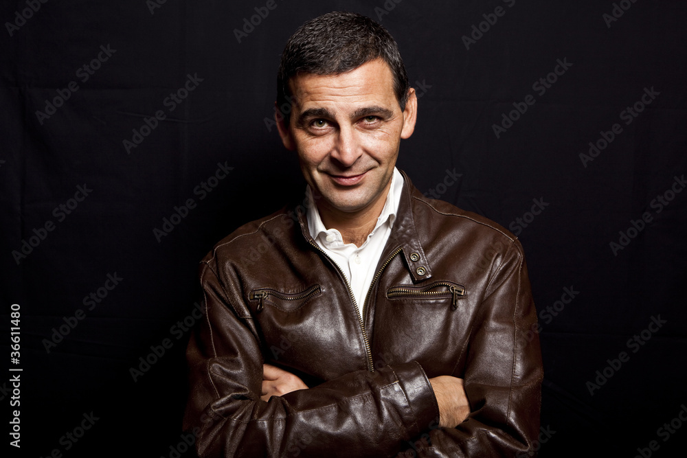 portrait of a cool mature man with leather jacket over black bac