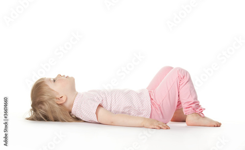 The baby girl is lying on the floor