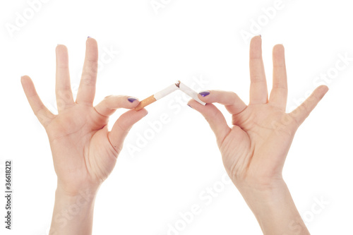Woman's hand crushing cigarette on white background